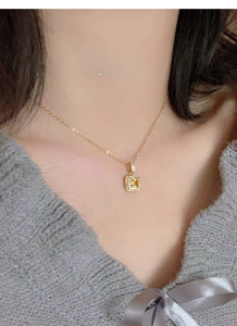 Close-up of S925 silver necklace with sparkling yellow square gemstone worn by a model