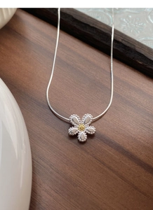 Detail showing S925 sterling silver daisy pendant with golden core on a snake chain