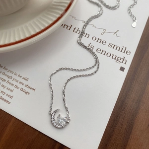 Collier élégant en argent sterling S925 avec pendentif lune et cœur sur une table en bois