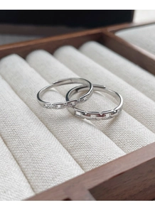 Detail of S925 sterling silver interlocking rings on a wooden jewelry box display