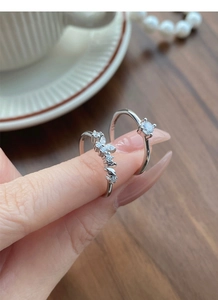 Macro shot of S925 sterling silver rings with zircon settings on walnut wood background