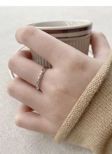 Detail of S925 sterling silver interlocking ring with zircon on a person's finger