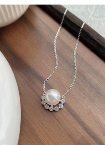 Macro view of S925 silver necklace with white pearl and sparkling zircon pendant