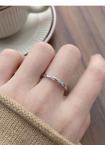 Close-up of S925 sterling silver Mobius ring with tiny cubic zirconia on a female finger