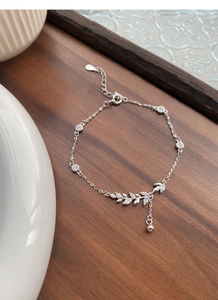 Macro detail of S925 sterling silver wheat ear bracelet with cubic zirconia on wood
