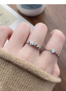 Detailed view of layered S925 silver rings featuring a zircon butterfly and single stone