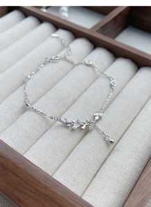 Close-up of S925 silver wheat ear bracelet with marquise zircon stones on wood box