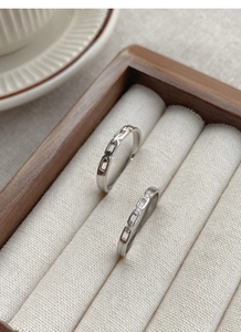 Macro shot of interlocking S925 sterling silver couple rings with small zircon detail