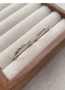 Macro detail of S925 silver Mobius rings set with twisted texture in a wooden jewelry box