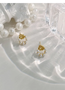 Détail de boucles d'oreilles rose doré vintage avec perles et ombres lumineuses d'eau
