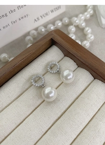 Détail de boucles d'oreilles perle en argent S925 avec zircons dans un coffret