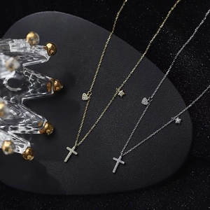 Silber- und Gold-Halsketten mit Kreuz-, Herz- und Sternanhängern auf schwarzem Herz-Display