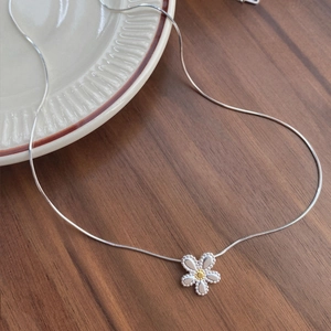 S925 Sterling Silver daisy flower pendant necklace with elegant snake chain on a wooden table