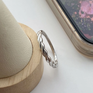 S925 sterling silver Mobius ring with twist design on a wooden jewelry display stand