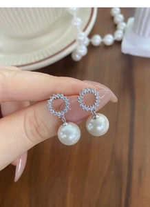 Gros plan d'élégantes boucles d'oreilles en argent S925 avec perles et anneau serti de cristaux