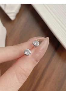 Macro detail of S925 sterling silver stud earrings featuring round bezel-set zircon stones