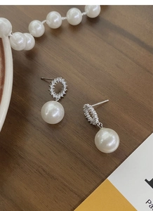 Gros plan de boucles d'oreilles en argent S925 et perles avec micro-incrustation de zircons