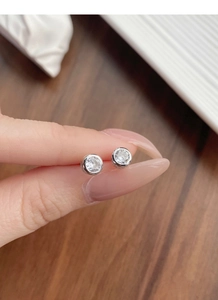 Close-up of minimalist S925 sterling silver stud earrings with sparkling cubic zirconia