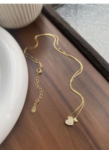 Détail du collier double cœur en argent S925 avec pavé de zircone et placage d'or fin