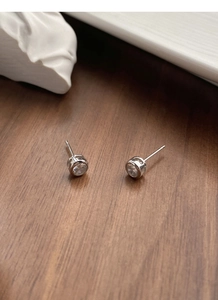 Close-up of minimalist S925 sterling silver stud earrings with round-cut zircon stones