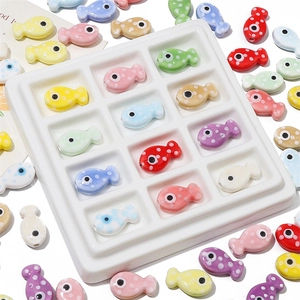 Dettaglio di perline in ceramica colorate a forma di pesce con pois per gioielli fai da te