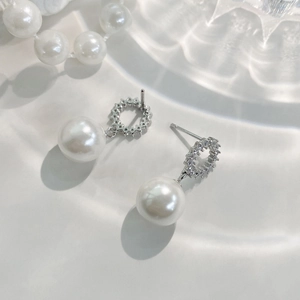 Élégantes boucles d'oreilles en argent S925 avec perles et zircons sur plateau blanc