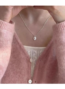 Nahaufnahme einer S925 Sterlingsilber-Ovalkette an einem Model mit rosa Strickmode