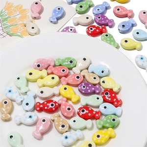 Dettaglio di perline colorate in ceramica a forma di pesce con pois per gioielli fai-da-te
