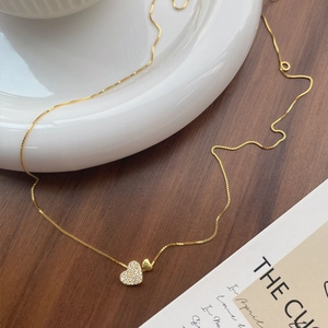 Collier coeur élégant en argent S925 doré avec zircons sur fond en bois sombre