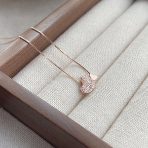 Collier avec pendentif cœur en or rose et cristaux brillants dans un écrin en bois