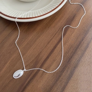 Minimalistische S925 Silberhalskette mit ovalem Anhänger auf edlem Holzinterieur