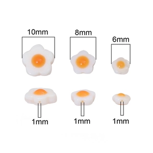 Flat lay of white shell flower resin beads with yellow centers in 10mm 8mm and 6mm sizes