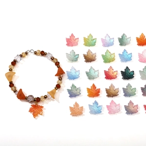DIY jewelry kit with orange beaded bracelet and variety of glass maple leaf pendants