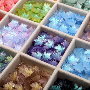 Detailed macro view of 16x15mm iridescent maple leaf glass beads for jewelry making