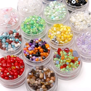 Assorted colorful glass and resin beads for DIY jewelry making in a plastic organizer