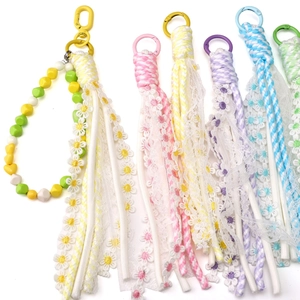 Detailed macro of handmade floral lace fringe tassels with colorful woven cotton ropes