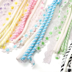 Detailed view of colorful daisy lace ribbons and twisted cord trimmings for DIY crafts
