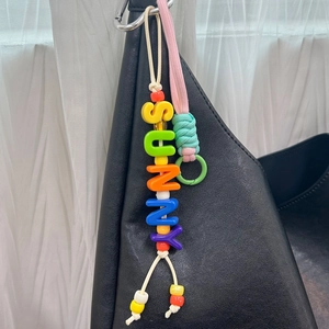 Ciondolo con lettere 3D SUNNY in acrilico colorato su una borsa di pelle nera