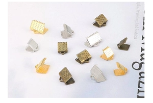 Detailed macro of metal ribbon end crimps with teeth for DIY jewelry making in multi-color
