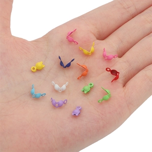Colorful metal jewelry connectors held in palm showing small size for DIY crafts