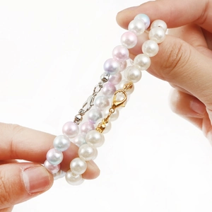 Handheld view of elegant pearl bracelets with gold and silver lobster clasps for DIY jewelry