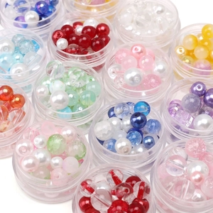 Macro shot of colorful glass seed beads and pearls in round storage boxes for DIY jewelry
