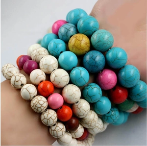 Colorful marble pattern round bead bracelets in blue, white, and pink layered on wrist