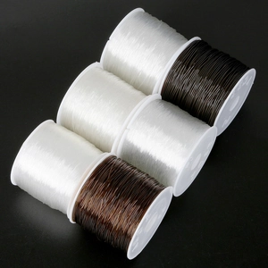 Close-up of elastic crystal bead cords in black, coffee, and clear on plastic spools