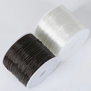 Macro detail of black and clear elastic crystal bead strings on white spools