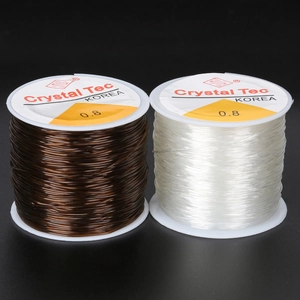 Detail view of 0.8mm crystal elastic string spools in transparent and brown colors
