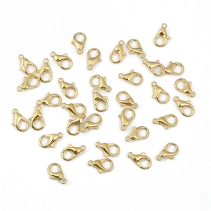 Fermoirs mousquetons dorés en alliage pour création de bijoux sur fond blanc