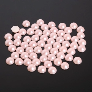 Detailed view of flatback semi-round ABS pearls in soft champagne pink for DIY nail art
