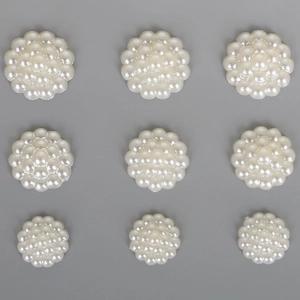 Flat lay of nine white ABS pearl flower patches for DIY hair accessories and crafts