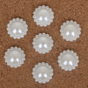 Flat lay of half round pearl flower patches for DIY hair accessories on cork
